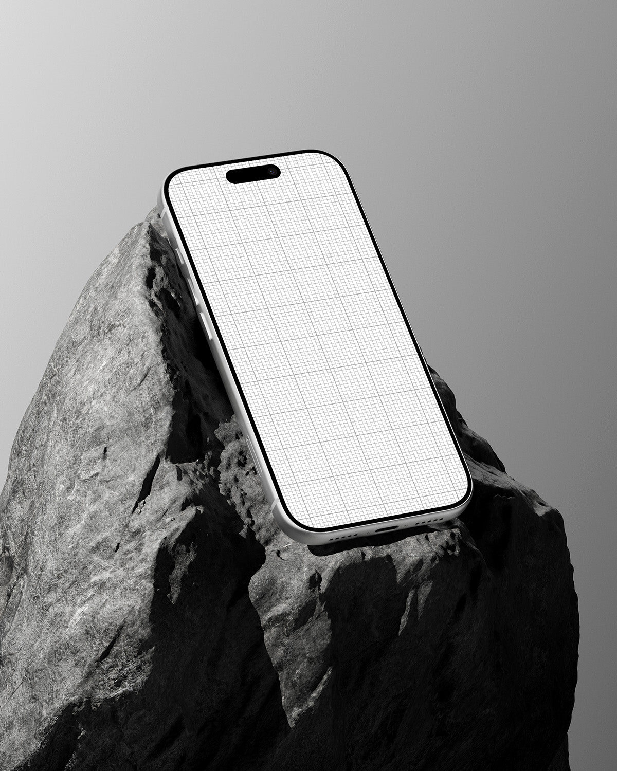 Phone with grid design on a rock against a gray background