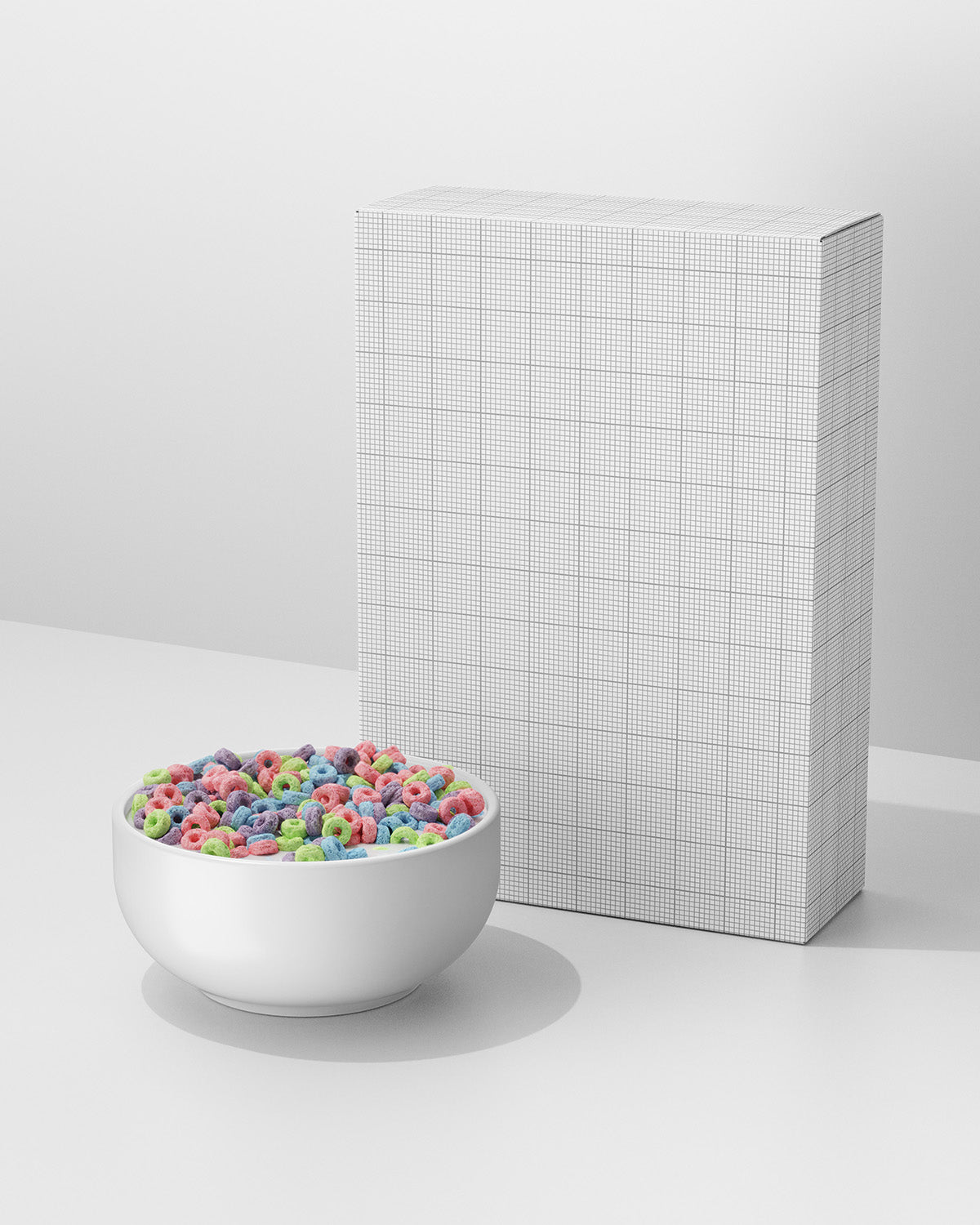 White bowl with colorful cereal next to a grid-patterned box on a white background mockup