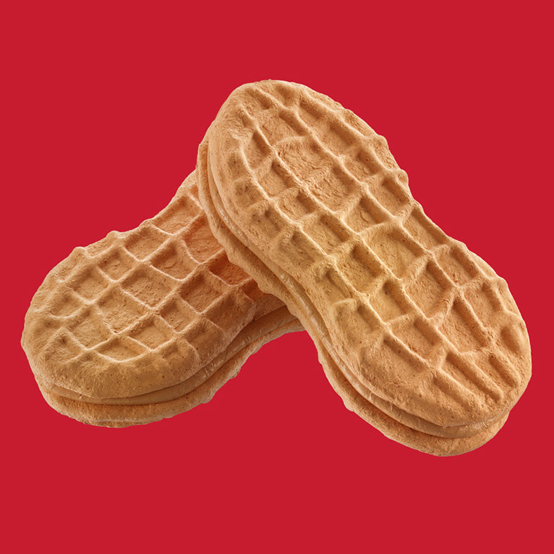 Two peanut butter waffle cookies stacked and crossed over each other, set against a solid red background.