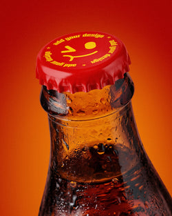 Glass bottle mockup with red crown cap and condensation droplets on orange background