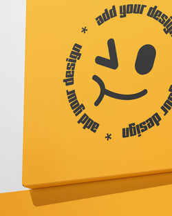 Yellow box with a smiley face design and text 'add your design' on a white background