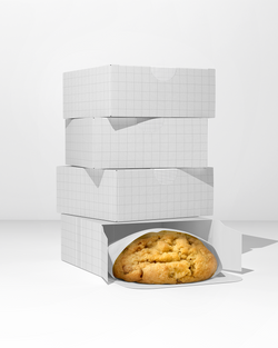 Stack of white gift boxes with a single cookie peeking out on a white background