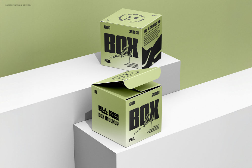 Two square boxes on minimalistic white blocks with a green background, one box open showing inner flap design.