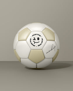 Soccer ball mockup with gold and white panels in front view on beige background